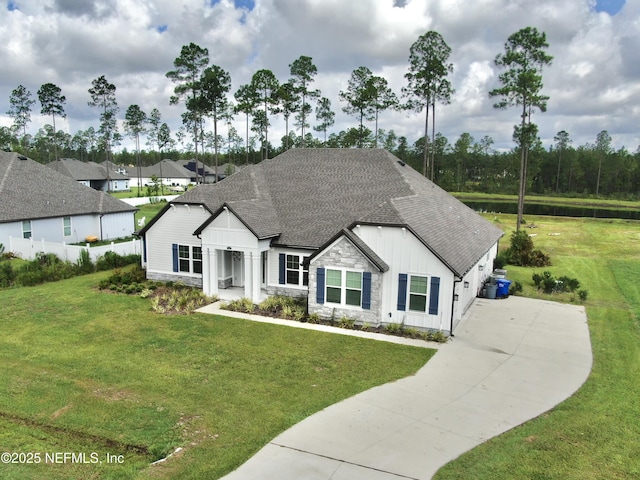 36461 Shortleaf Ave, Hilliard, FL 32046 - view of front of home with board and batten siding, roof with shingles, stone siding, and a front yard