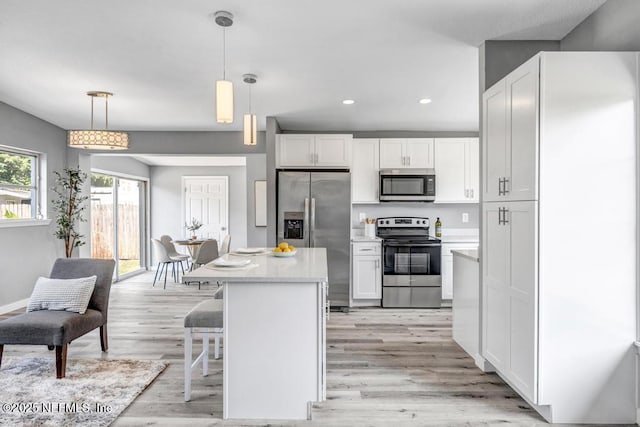 6903 Mayapple Rd, Jacksonville, FL 32211 - kitchen featuring appliances with stainless steel finishes, white cabinetry, light countertops, light wood-style floors, and recessed lighting