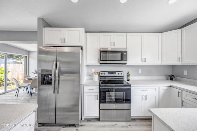 6903 Mayapple Rd, Jacksonville, FL 32211 - kitchen with appliances with stainless steel finishes, white cabinets, light wood-type flooring, light countertops, and recessed lighting
