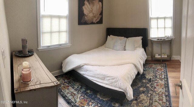 319 1st Ave N Unit 1-B, Jacksonville Beach, FL 32250 - bedroom featuring multiple windows, wood finished floors, and baseboards