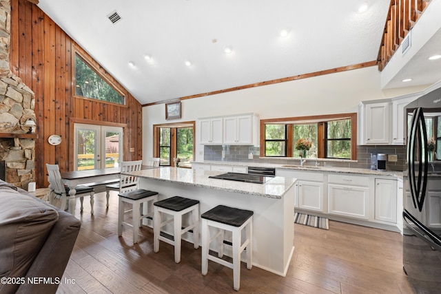 156 County Road 13, Saint Augustine, FL 32092 - kitchen with high vaulted ceiling, black appliances, plenty of natural light, backsplash, and wooden walls