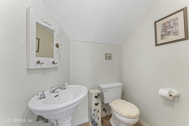 156 County Road 13, Saint Augustine, FL 32092 - half bath with lofted ceiling, a textured ceiling, a sink, toilet, and baseboards