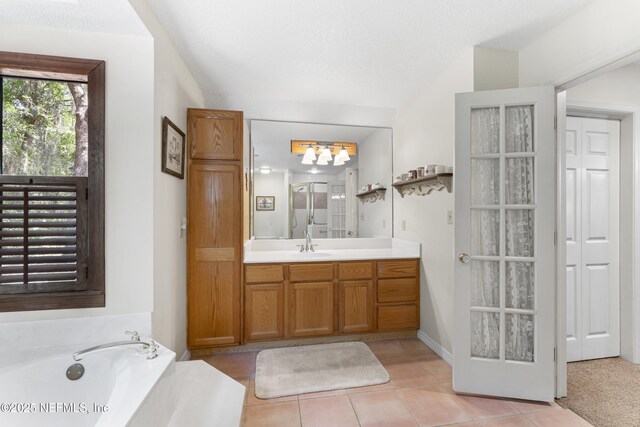156 County Road 13, Saint Augustine, FL 32092 - bathroom with vanity, a garden tub, tile patterned floors, a chandelier, and vaulted ceiling