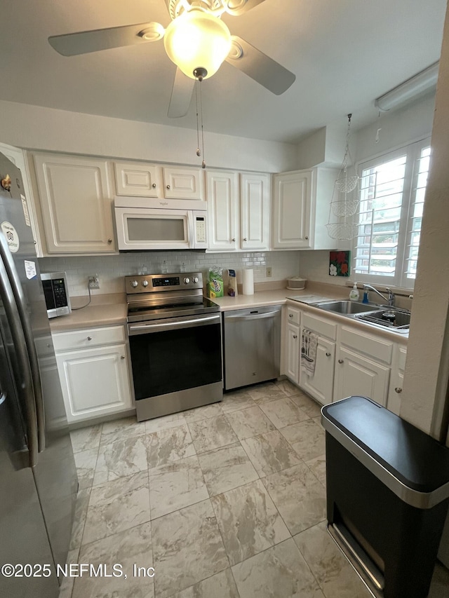 4915 Baymeadows Rd Unit 11E, Jacksonville, FL 32217 - kitchen featuring stainless steel appliances, light countertops, white cabinetry, a ceiling fan, and light marble finish floors