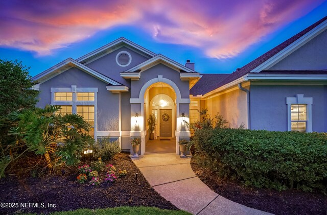 828 Lotus Ln N, Saint Johns, FL 32259 - view of front of house with a chimney and stucco siding