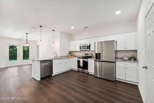 127 Azalea Cir, Palatka, FL 32177 - kitchen with stainless steel appliances, a sink, a peninsula, dark wood-type flooring, and white cabinetry