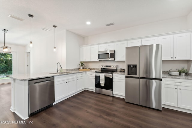 127 Azalea Cir, Palatka, FL 32177 - kitchen with stainless steel appliances, a sink, a peninsula, dark wood-type flooring, and white cabinetry