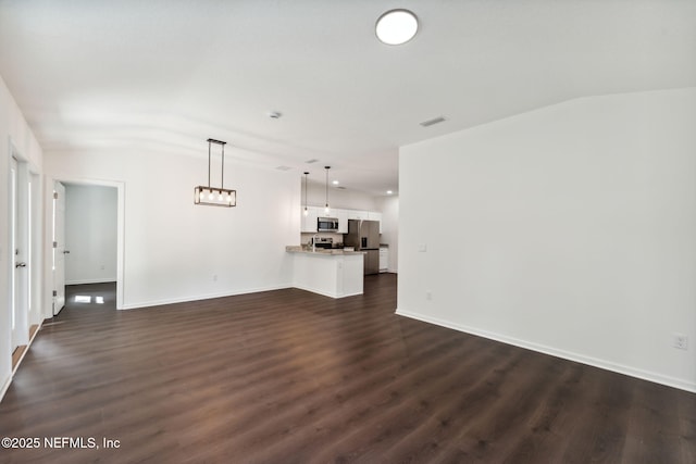 127 Azalea Cir, Palatka, FL 32177 - unfurnished living room with vaulted ceiling, dark wood-style floors, and baseboards