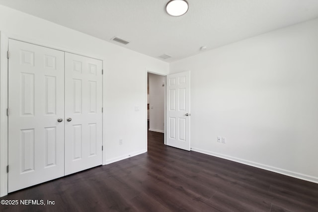127 Azalea Cir, Palatka, FL 32177 - unfurnished bedroom featuring dark wood-style floors, baseboards, and a closet
