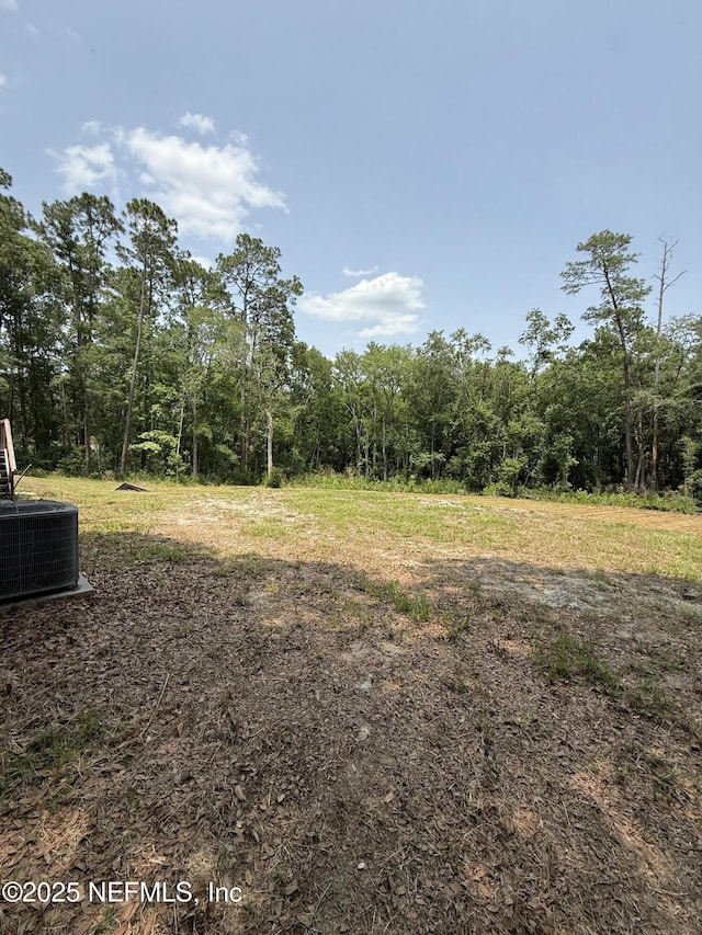 74 Conifer Cir, Middleburg, FL 32068 - view of yard with central AC unit and a wooded view