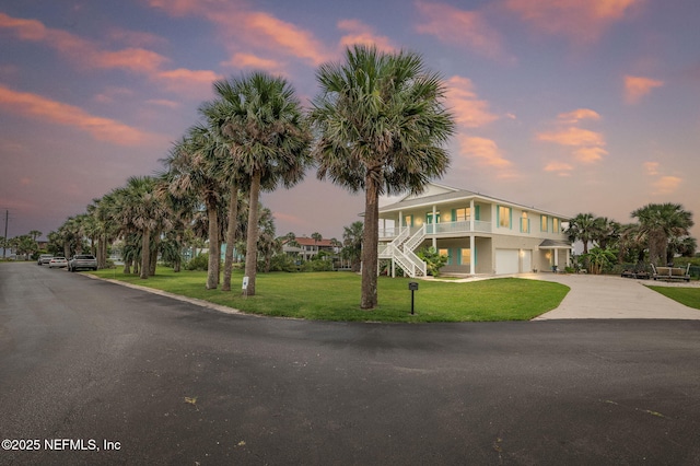 231 Barrataria Dr, Saint Augustine, FL 32080 - raised beach house featuring stairway, a garage, a yard, driveway, and a porch