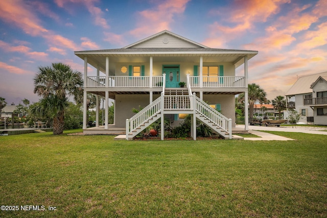 231 Barrataria Dr, Saint Augustine, FL 32080 - back of property at dusk with a porch, stairway, and a yard