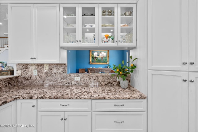 231 Barrataria Dr, Saint Augustine, FL 32080 - kitchen with glass insert cabinets, white cabinetry, light stone counters, and tasteful backsplash