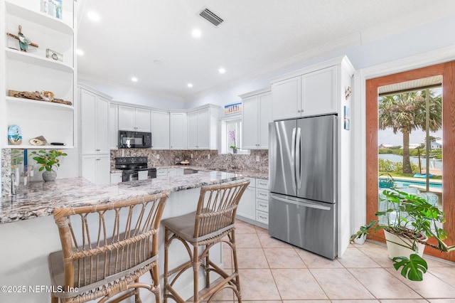 231 Barrataria Dr, Saint Augustine, FL 32080 - kitchen with black appliances, open shelves, backsplash, ornamental molding, and a peninsula