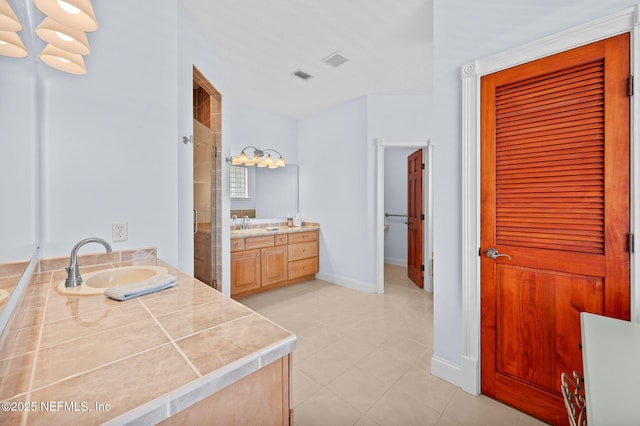 231 Barrataria Dr, Saint Augustine, FL 32080 - full bathroom with two vanities, a shower stall, baseboards, and tile patterned floors