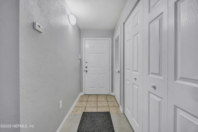 425 S Villa San Marco Dr Unit 302, Saint Augustine, FL 32086 - hallway featuring a textured wall, baseboards, and light tile patterned floors