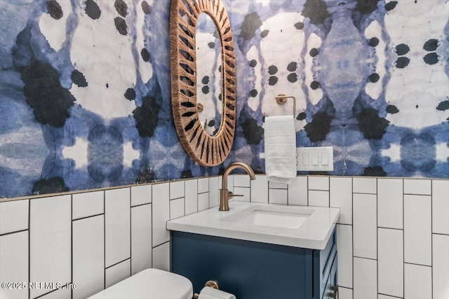 901 Ocean Blvd Unit 91, Atlantic Beach, FL 32233 - bathroom featuring vanity, wallpapered walls, toilet, tile walls, and wainscoting