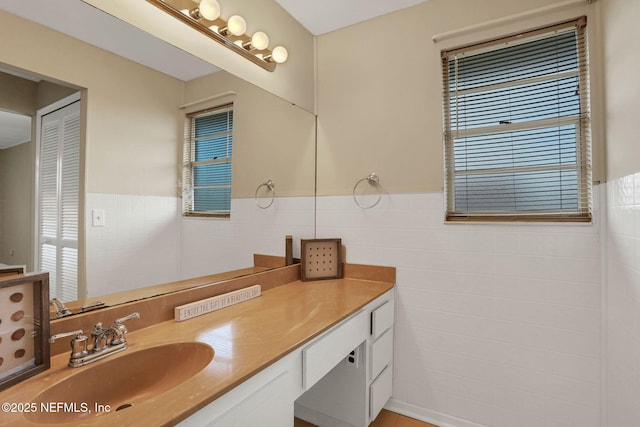 2650 Cardigan Ct, Orange Park, FL 32065 - bathroom with tile walls, vanity, and a wainscoted wall