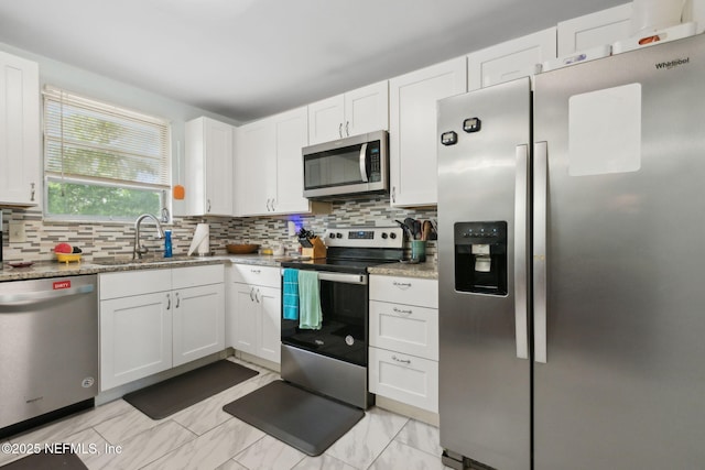 7456 Burlingame Dr S, Jacksonville, FL 32211 - kitchen featuring appliances with stainless steel finishes, backsplash, a sink, and white cabinetry