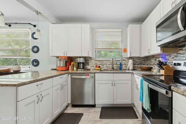 7456 Burlingame Dr S, Jacksonville, FL 32211 - kitchen featuring appliances with stainless steel finishes, a sink, tasteful backsplash, and white cabinetry