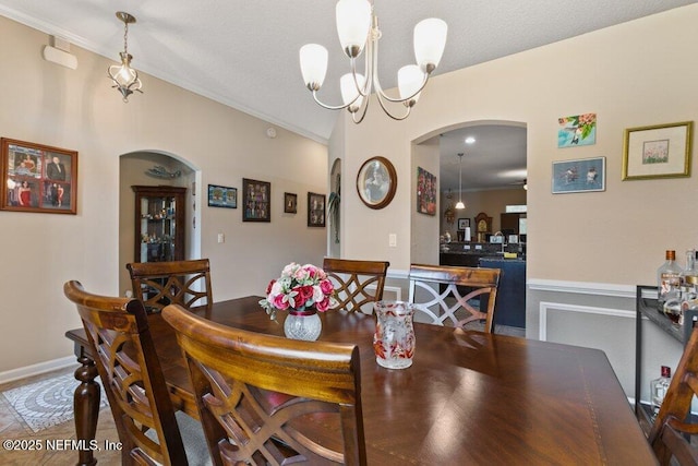 3912 Pipit Pt, Middleburg, FL 32068 - dining space featuring arched walkways, a chandelier, crown molding, wainscoting, and lofted ceiling