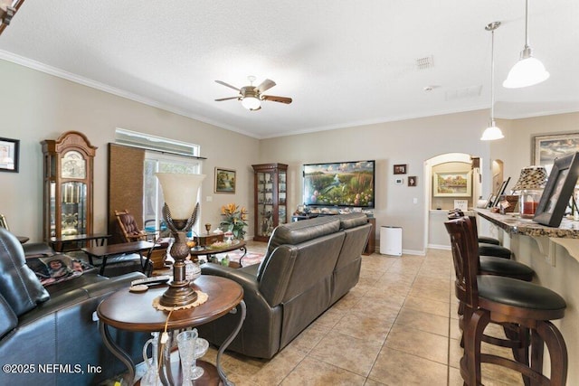 3912 Pipit Pt, Middleburg, FL 32068 - living area featuring ornamental molding, a ceiling fan, light tile patterned floors, baseboards, and arched walkways
