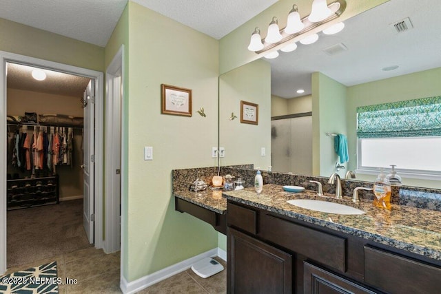 3912 Pipit Pt, Middleburg, FL 32068 - bathroom featuring tile patterned floors, a spacious closet, a stall shower, and vanity