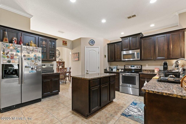 3912 Pipit Pt, Middleburg, FL 32068 - kitchen featuring stainless steel appliances, a sink, arched walkways, stone countertops, and dark brown cabinets