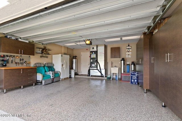 3912 Pipit Pt, Middleburg, FL 32068 - garage with white fridge with ice dispenser, a garage door opener, and water heater