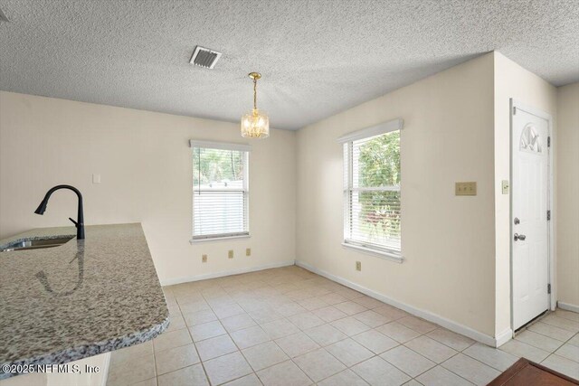 1528 Jordan St, Atlantic Beach, FL 32233 - unfurnished dining area with a sink, plenty of natural light, light tile patterned floors, a chandelier, and a textured ceiling