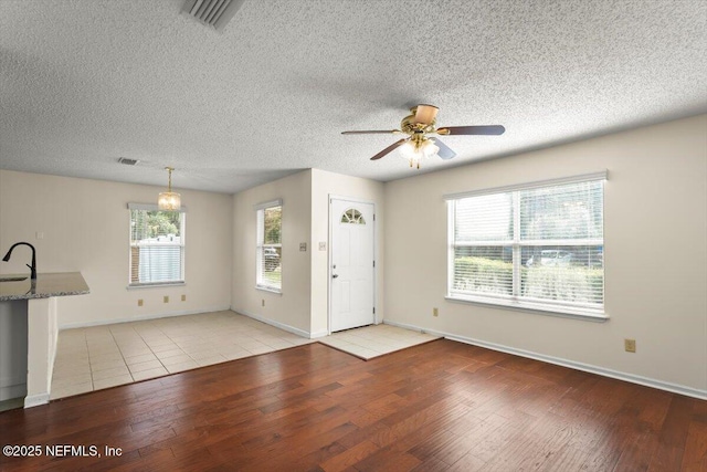 1528 Jordan St, Atlantic Beach, FL 32233 - foyer entrance featuring light wood-type flooring, ceiling fan, baseboards, a textured ceiling, and a chandelier