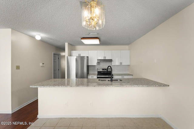 1528 Jordan St, Atlantic Beach, FL 32233 - kitchen featuring appliances with stainless steel finishes, a sink, under cabinet range hood, light stone counters, and white cabinetry
