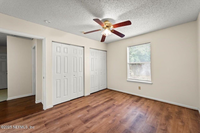 1528 Jordan St, Atlantic Beach, FL 32233 - unfurnished bedroom featuring multiple closets, wood finished floors, baseboards, a textured ceiling, and ceiling fan