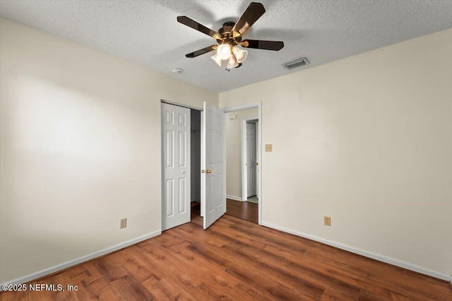 1528 Jordan St, Atlantic Beach, FL 32233 - unfurnished bedroom featuring wood finished floors, baseboards, a closet, a textured ceiling, and ceiling fan