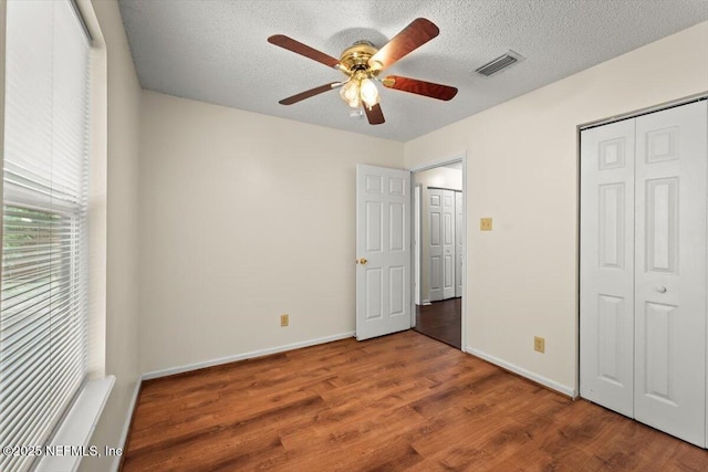 1528 Jordan St, Atlantic Beach, FL 32233 - unfurnished bedroom featuring wood finished floors, a closet, baseboards, a textured ceiling, and a ceiling fan