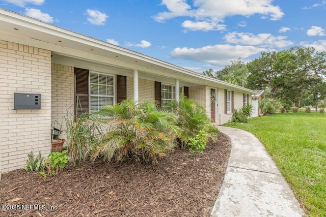 2041 Mill Creek Rd, Jacksonville, FL 32211 - view of exterior entry with brick siding and a lawn