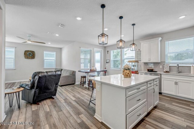 4604 Clapboard Crossing Way, Jacksonville, FL 32226 - kitchen with a sink, light wood-style flooring, light countertops, white cabinetry, and recessed lighting