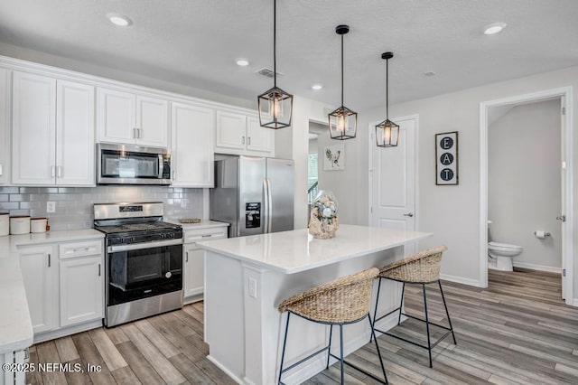 4604 Clapboard Crossing Way, Jacksonville, FL 32226 - kitchen featuring appliances with stainless steel finishes, light wood finished floors, light countertops, white cabinetry, and recessed lighting