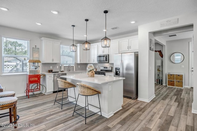 4604 Clapboard Crossing Way, Jacksonville, FL 32226 - kitchen with stainless steel appliances, a sink, light wood-style flooring, light countertops, and recessed lighting
