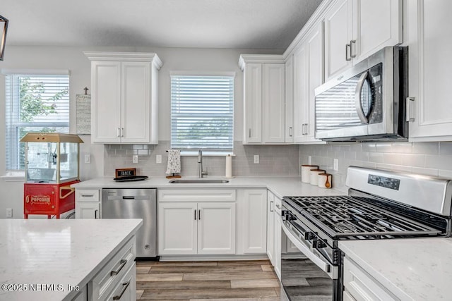 4604 Clapboard Crossing Way, Jacksonville, FL 32226 - kitchen with stainless steel appliances, a sink, healthy amount of natural light, and white cabinets