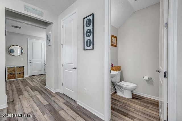 4604 Clapboard Crossing Way, Jacksonville, FL 32226 - bathroom with wood finished floors, toilet, baseboards, and vaulted ceiling