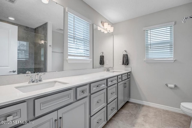 4604 Clapboard Crossing Way, Jacksonville, FL 32226 - bathroom featuring double vanity, tiled shower, toilet, baseboards, and tile patterned floors