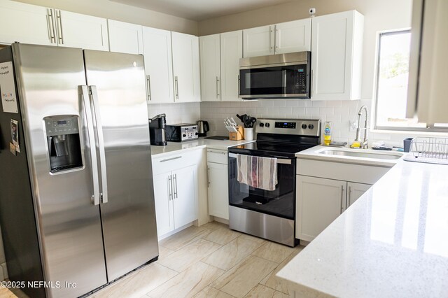 14 Ballard Ln, Palm Coast, FL 32137 - kitchen featuring appliances with stainless steel finishes, tasteful backsplash, white cabinetry, and light stone countertops