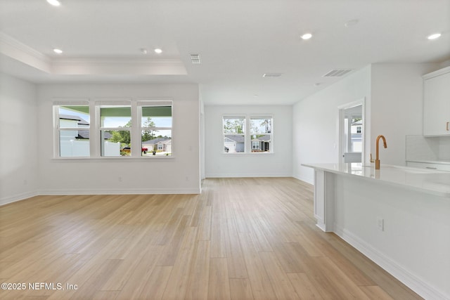 2446 Glade Ln, Green Cove Springs, FL 32043 - unfurnished living room featuring light wood-type flooring, ornamental molding, recessed lighting, a raised ceiling, and baseboards
