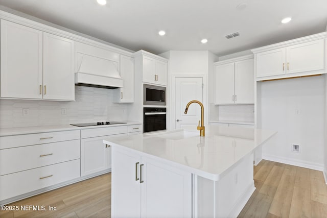 2446 Glade Ln, Green Cove Springs, FL 32043 - kitchen with a sink, custom exhaust hood, black appliances, white cabinetry, and backsplash