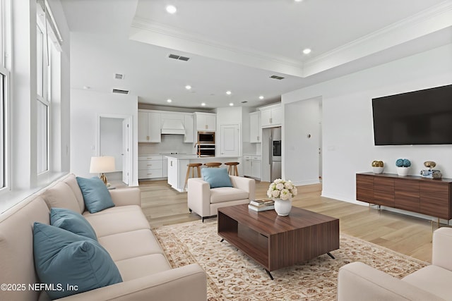 2446 Glade Ln, Green Cove Springs, FL 32043 - living room featuring light wood finished floors, a tray ceiling, ornamental molding, and recessed lighting