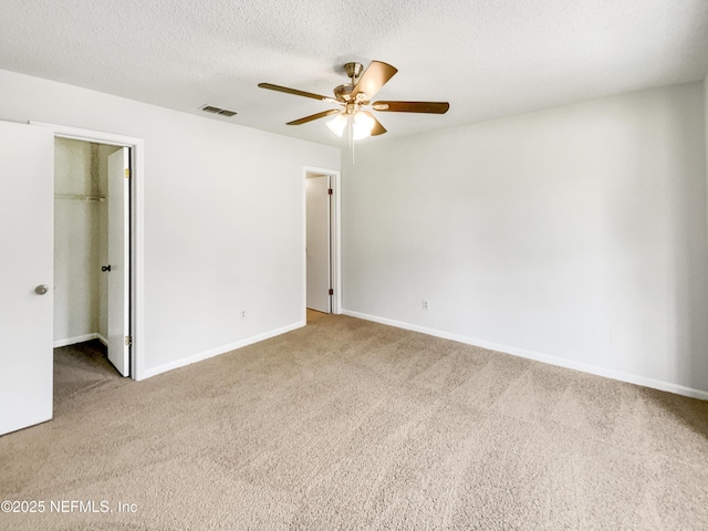 2439 Burns Dr, Middleburg, FL 32068 - unfurnished bedroom with carpet flooring, a walk in closet, baseboards, a closet, and a textured ceiling