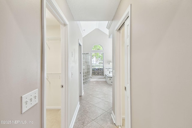 13022 Huntley Manor Dr, Jacksonville, FL 32224 - hallway featuring light tile patterned floors, lofted ceiling, and baseboards