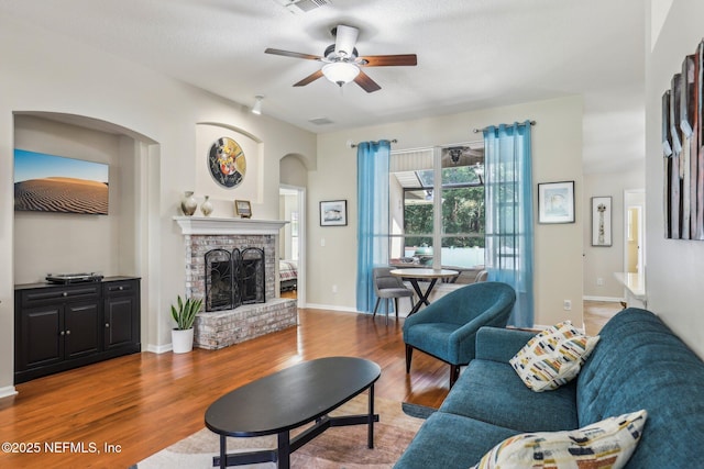 1346 N Kyle Way, Jacksonville, FL 32259 - living room with a ceiling fan, wood finished floors, arched walkways, a brick fireplace, and baseboards