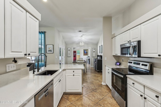 1346 N Kyle Way, Jacksonville, FL 32259 - kitchen with stainless steel appliances, a sink, a peninsula, light countertops, and light tile patterned flooring